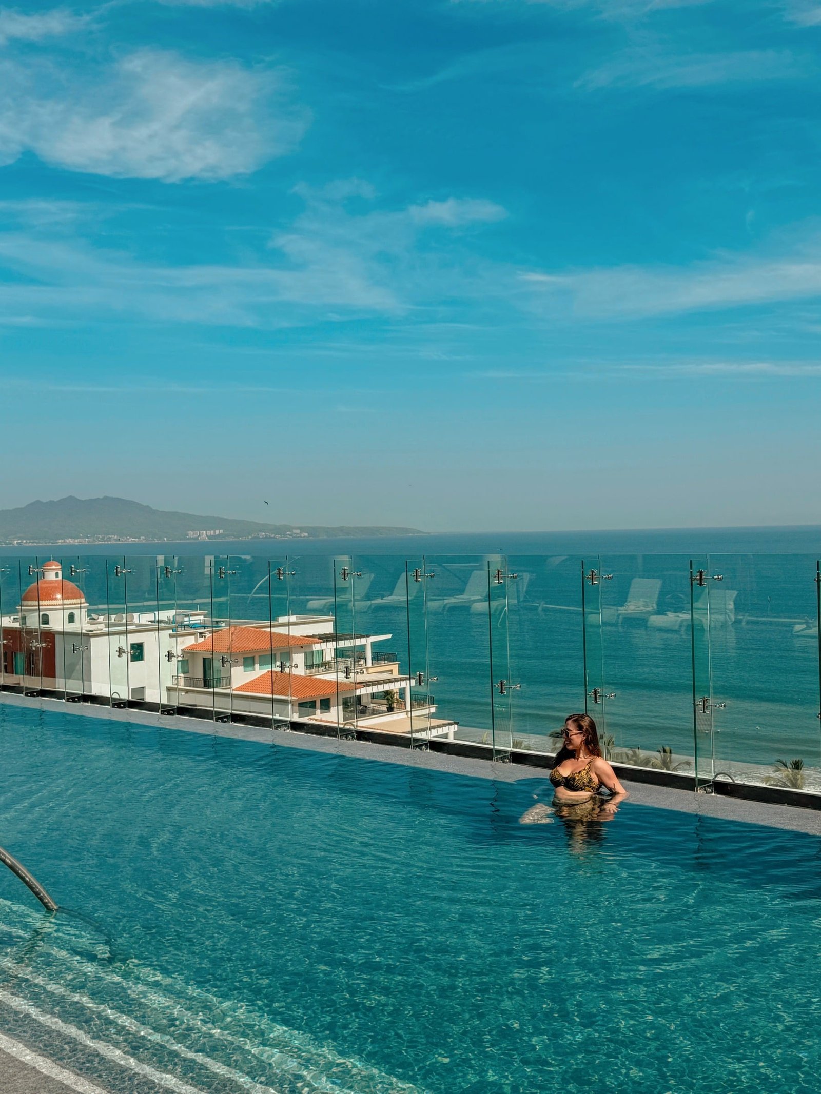 Julia Grimberg in a rooftop pool overlooking the coast